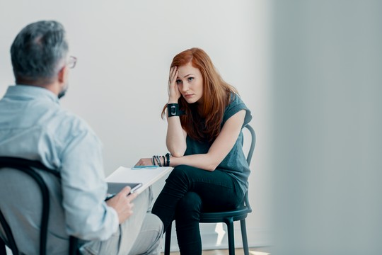 kobieta rozmawia z psychoterapeutą w jasnym pokoju